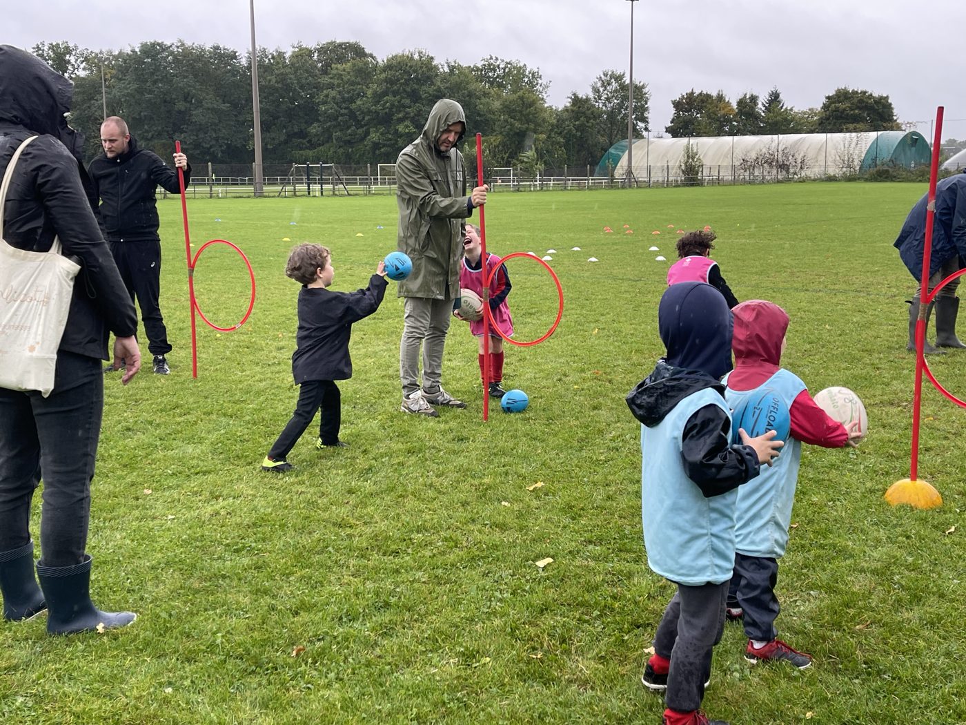 Groupe baby-rugby au sol, ballon en main
